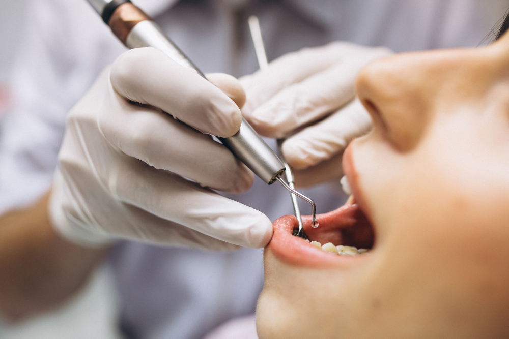 mulher de boca aberta e mãos do dentista com instrumentos