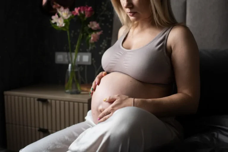 mulher gravida pegando na barriga com tons torrosos na imagem