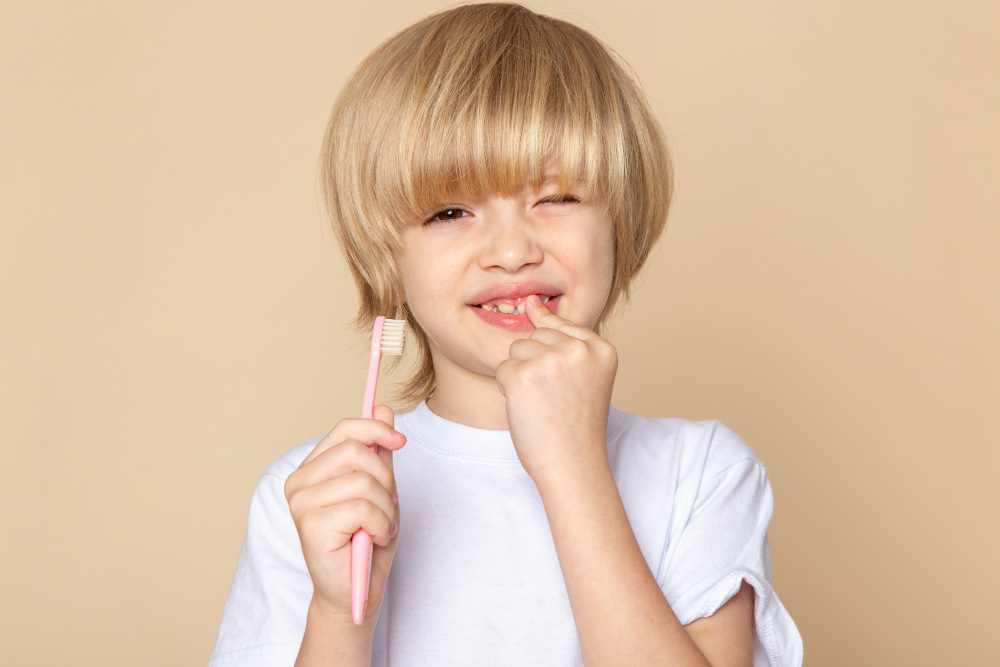 Criança segurando escova de dente infantil