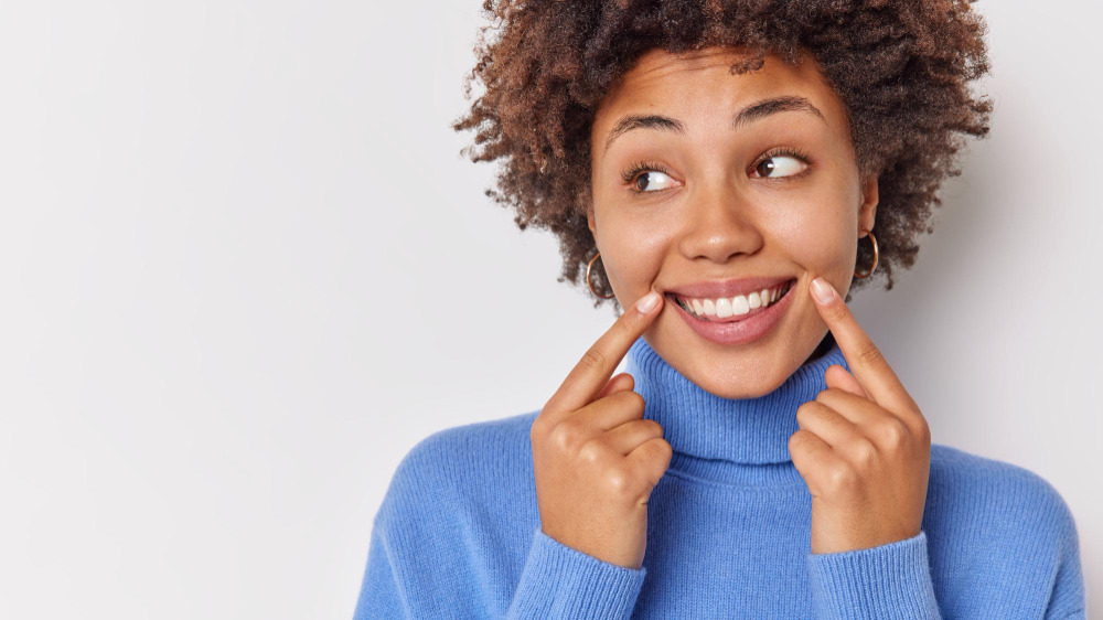 Pessoa sorrindo se preocupa com dentes amarelados